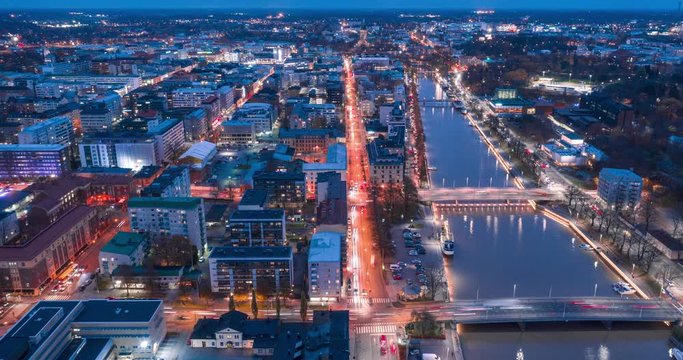 Aerial timelapse footage of city streets at evening during rush hour. Fast moving traffic on the city streets. 4K time-lapse video.