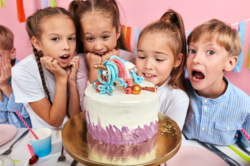 what amazing creative cake. kids being shocked at unusual dessert, isolated pink background