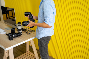 photography check lense and equipment with camera before Portrait of a photographer covering him face with the camera in studio photo ,  photography concept
