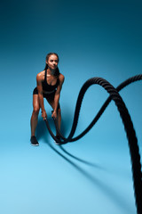 beautiful muscular athlete girl preparing for a competition, woman taking part in the competition.full length photo. isolated blue background, leisure concept