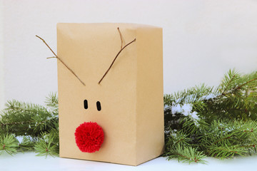 christmas gift box decorated with a red reindeer nose and antlers