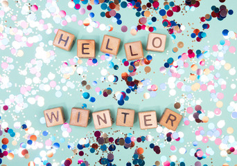 Hello winter word written on wood block. Greeteng card concept on mint background.