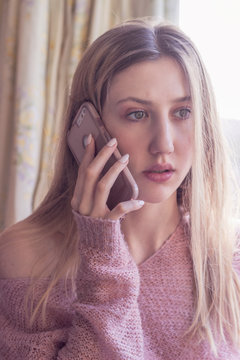 Young Woman Talking On The Phone Looks Worried, Distraught