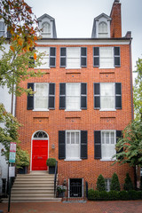 Fototapeta na wymiar Georgian colonial style multi story luxury house with dormer windows and red brick facade in Georgetown Washington DC USA