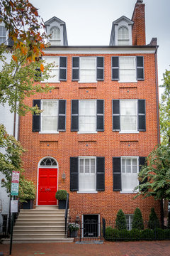 Georgian colonial style multi story luxury house with dormer windows and red brick facade in Georgetown Washington DC USA