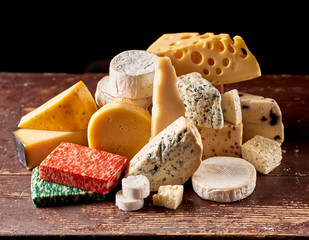 Various types of cheese on rustic wooden table,