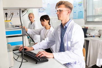 Scientists in white coats working at laboratory