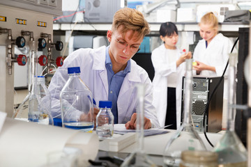 Fototapeta premium student of Faculty of Biology writing results in test chart