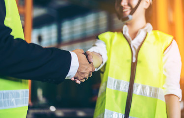 concept of company work or worker, team and successful. Worker with helmets shaking hands successful negotiation and agreement of partnership communication in an industrial facility Asia