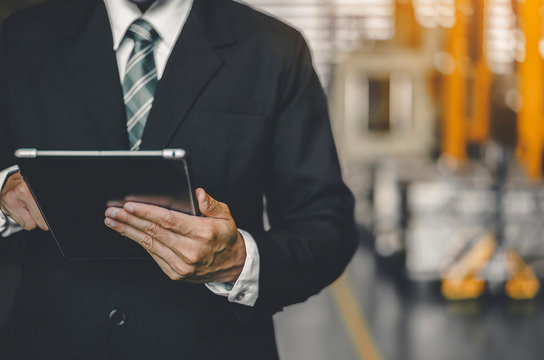 Manufacturer or businessman working on tablet while searching for technical data Industry logistic or Import and export Factory. Maintenance engineer using digital tablet control, inspect Project