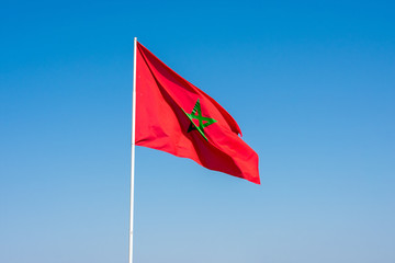 Moroccan Flag against clear blue sky on city walls in Essaouira Morocco