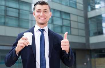 Office worker is drinking coffee outdoors