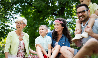 Happy family playing and enjoying picnic with children outside
