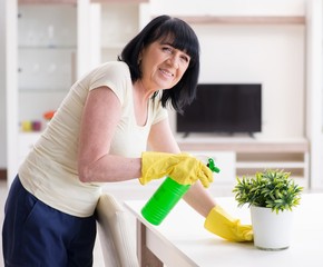 Old mature woman tired after house chores