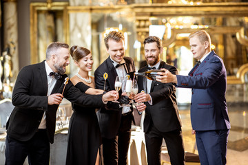 Well-dressed people celebrating New Year indoors