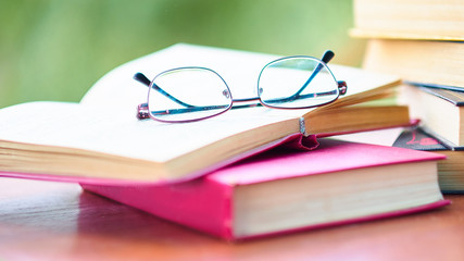 glasses and open book. best books home library background. read vintage books in a row. college library table. publishing