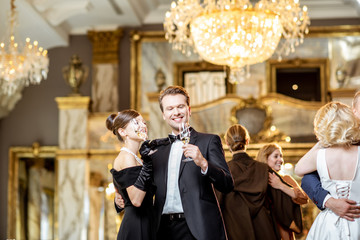 Group of elegant people dancing indoors