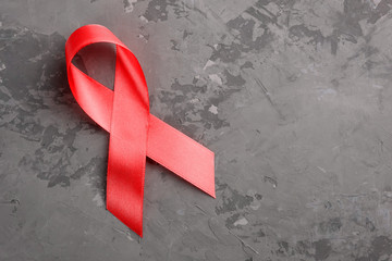 red ribbon on a concrete background. 1 December World AIDS Day, HIV illness campaign. Copy space for text