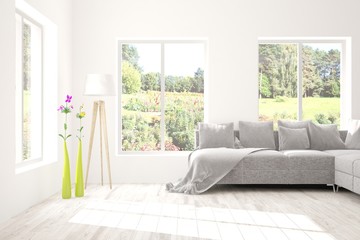 Stylish room in white color with sofa and summer landscape in window. Scandinavian interior design. 3D illustration