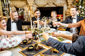 Elegantly dressed people celebrating New Year holiday indoors