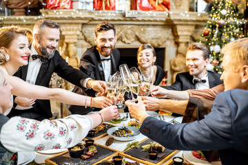 Elegantly dressed people celebrating New Year holiday indoors