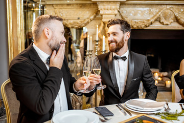 Elegantly dressed two men having a festive dinner on New Year's Eve