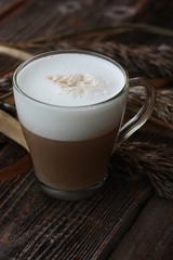 Delicious cappuccino with milk on a wooden table