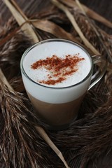Delicious coffee cappuccino with cinnamon on wooden table