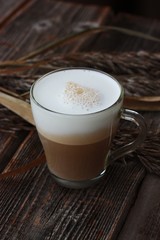 Delicious cappuccino with milk on a wooden table