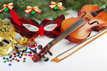Violin, carnival masks, branches of spruce and New Year decorations.