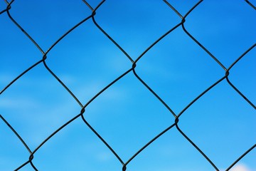 Black metal mesh on the background and blue sky 