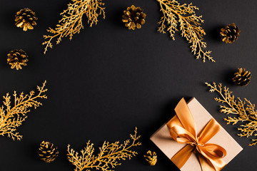 Christmas card with golden fir, pine cone and gift  flat lay