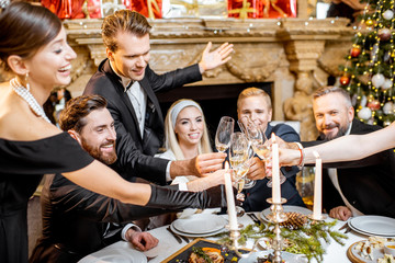 Elegantly dressed people celebrating New Year holiday indoors