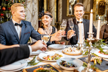 Elegantly dressed people having a festive dinner indoors