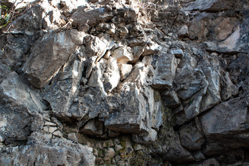A rocky deposit with broken stone pieces reflecting sunlight on a winter morning in the mountains