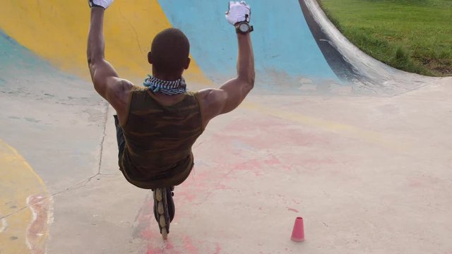 Sportsman riding rollerblade on one foot and one wheel