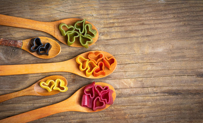 Heart shape macaroni pasta on wooden spoons