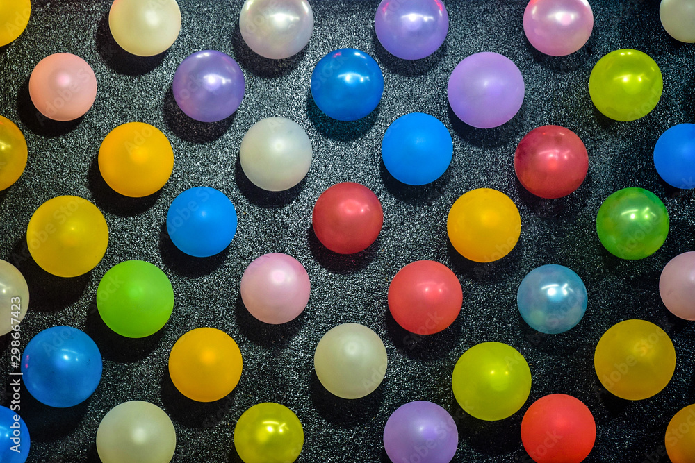 Wall mural rows of large number of colorful balloons on a black background, beautiful pattern. selective focus.