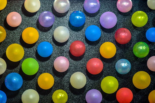 Rows of large number of colorful balloons on a black background, beautiful pattern. Selective focus.