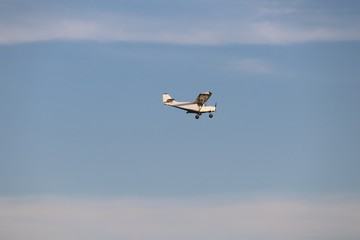 Small single-propeller plane flying over the blue sky. Concept Treaty on Open Skies