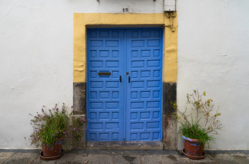 Blue door in a white wall in a street of Cordoba, in Andalucia, in Spain.