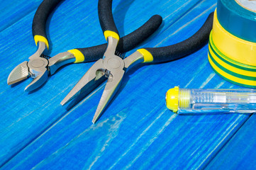 Tools and spare parts for electrician on blue wooden boards