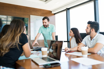 Leader Gesturing While Explaining Coworkers In Meeting