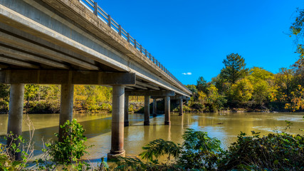 Fototapeta na wymiar Highway bridge crossing Haw River at Swepsonvile River Park