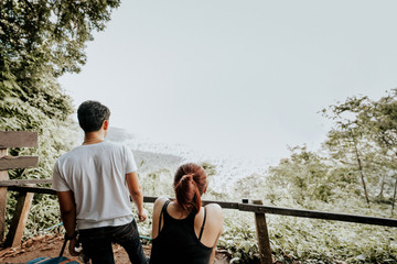 local adventure travel activity from beautiful tropical forest with sunlight and asian couple stand and see nature view
