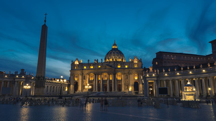 Fototapeta premium A night picture of The Papal Basilica of St. Peter in the Vatican. St Peter's, Bernini's colonnade and Maderno's fountain at night during blure hour.