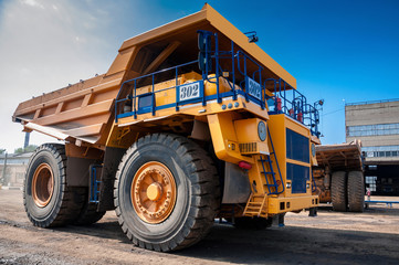 heavy yellow quarry dump truck at repair station at sunny cloudless day