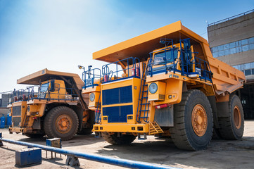 Fototapeta na wymiar heavy yellow quarry dump truck at repair station at sunny cloudless day