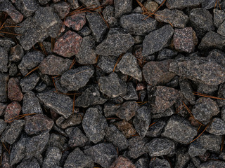 Stone gravel texture background with orange dry pine needles