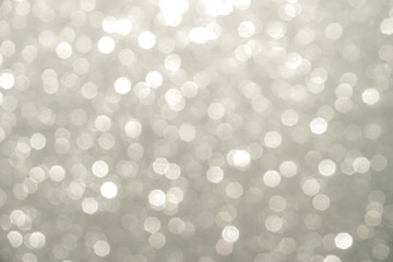 Silver Sparkling Lights Festive background with texture. Abstract Christmas twinkled bright bokeh defocused and Falling stars. Winter Card or invitation	
